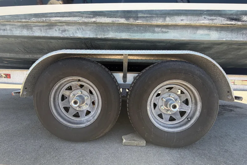 Slide: The Image of Trailer wheels of a 2018 Sea Ray Sundancer 260 boat on pavement. - 104
