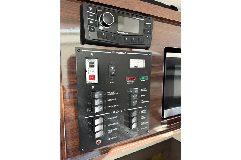 Slide: The Image of Control panel of a 2018 Sea Ray Sundancer 260 boat, featuring electrical switches and stereo system. - 11