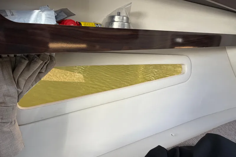 Slide: The Image of Interior view of 2018 Sea Ray Sundancer 260 boat window with shelf and curtain. - 25