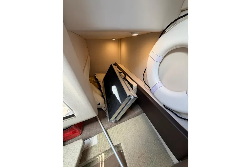 Slide: The Image of Interior cabin of 2018 Sea Ray Sundancer 260 with life preserver and folded table. - 29