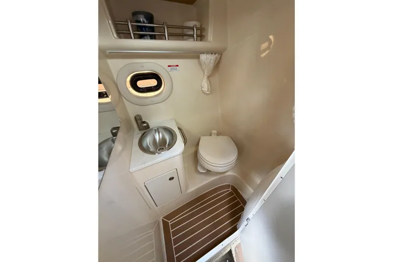 Slide: The Image of 2018 Sea Ray Sundancer 260 bathroom with sink, toilet, and porthole window. - 30