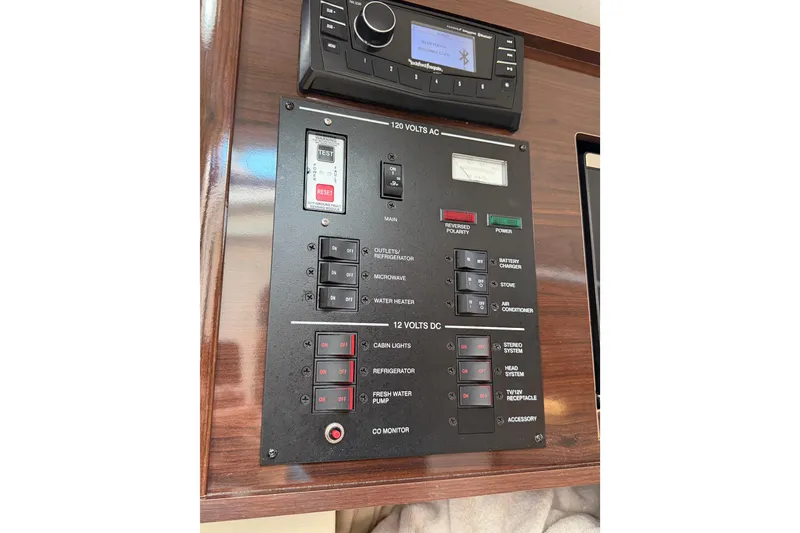 Slide: The Image of Control panel of a 2018 Sea Ray Sundancer 260 boat, featuring various switches and a stereo system. - 33