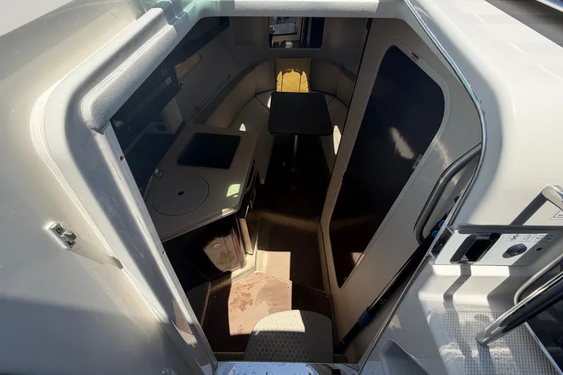 Slide: The Image of Interior cabin of 2018 Sea Ray Sundancer 260, featuring seating and compact kitchenette. - 35