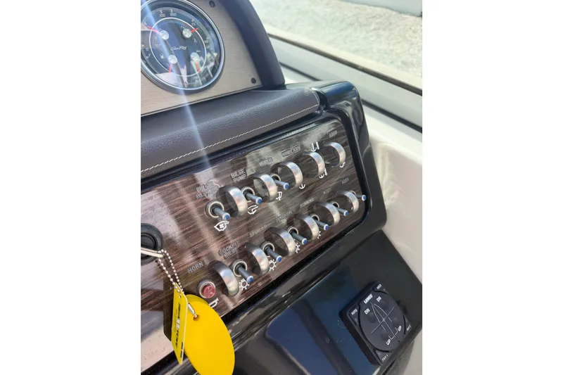 Slide: The Image of Control panel of a 2018 Sea Ray Sundancer 260 boat with switches and gauges. - 56