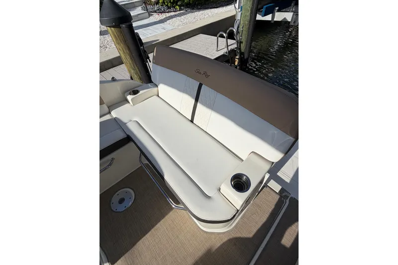 Slide: The Image of 2018 Sea Ray Sundancer 260 boat seating with cup holder, docked by water. - 58
