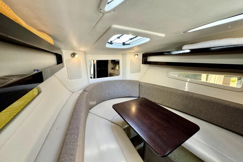 Slide: The Image of Interior of 2018 Sea Ray Sundancer 260, featuring a cozy dining area with a wooden table. - 6