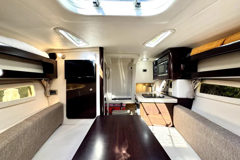 Slide: The Image of Interior of 2018 Sea Ray Sundancer 260, featuring cozy seating, kitchenette, and modern amenities. - 7