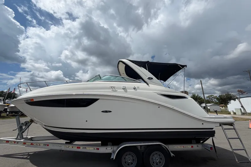Slide: The Image of 2018 Sea Ray Sundancer 260 boat on trailer under cloudy sky. - 9