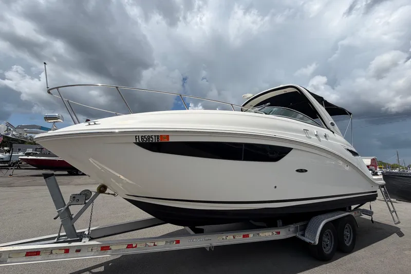 Slide: The Image of 2018 Sea Ray Sundancer 260 boat on trailer under cloudy sky. - 10