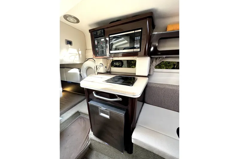 Slide: The Image of Compact kitchen area in 2018 Sea Ray Sundancer 260 boat, featuring microwave and sink. - 9