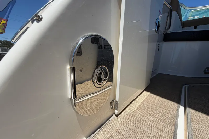Slide: The Image of 2018 Sea Ray Sundancer 260 boat interior with chrome details and beige flooring. - 95