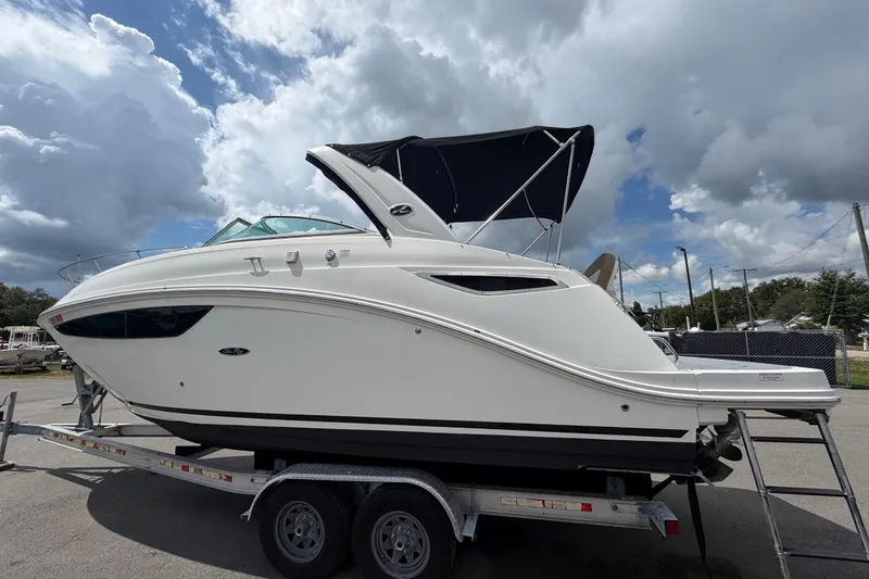 Slide: The Image of 2018 Sea Ray Sundancer 260 boat on trailer under cloudy sky. - 8