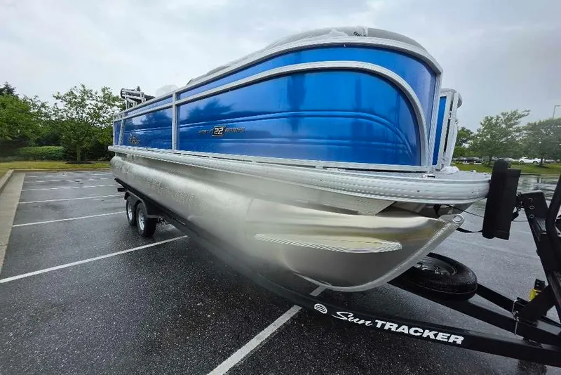 The Image of 2026 Sun Tracker Party Barge 22 RF XP3 pontoon boat on trailer in parking lot. - 0