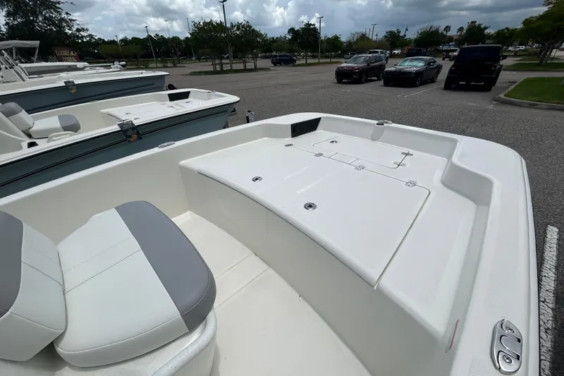 Slide: The Image of 2026 Mako Pro Skiff 15 CC boat interior with seating and storage in a parking lot. - 3