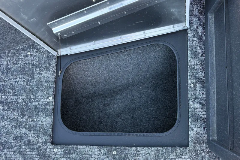 Slide: The Image of Storage compartment in 2026 Tracker Pro Guide V-175 WT boat, featuring carpeted interior. - 26