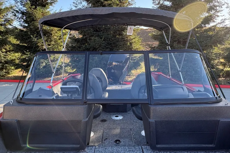 Slide: The Image of 2026 Tracker Pro Guide V-175 WT boat with canopy, parked outdoors near trees. - 18