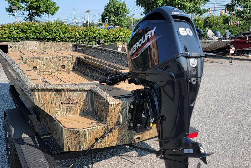 Slide: The Image of 2026 Tracker Grizzly 1756 T Marsh boat with Mercury 60 outboard motor, camo design. - 2