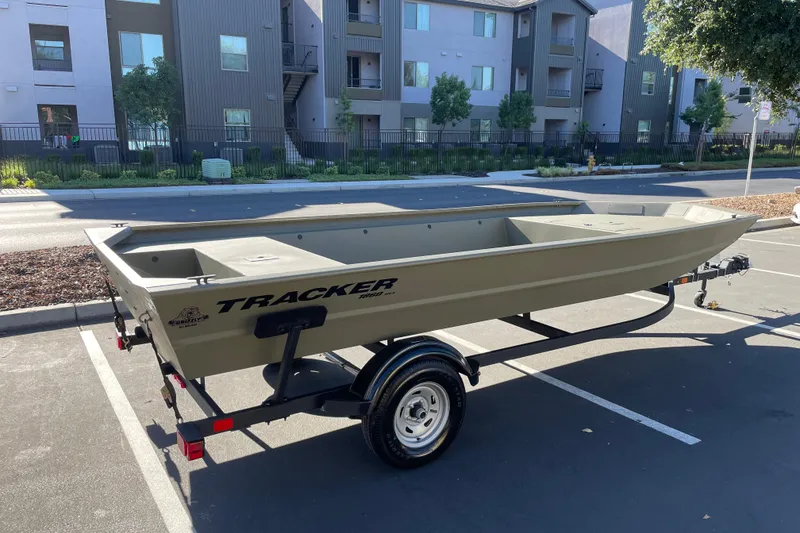 Slide: The Image of 2026 Tracker Grizzly 1860 Utility boat on trailer in parking lot. - 2