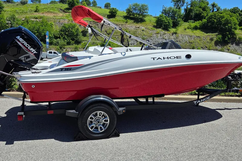 The Image of 2026 Tahoe T16 boat with red hull on trailer, parked outdoors. - 0