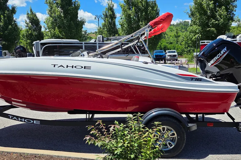Slide: The Image of 2026 Tahoe T16 boat with red hull on trailer, parked outdoors. - 1