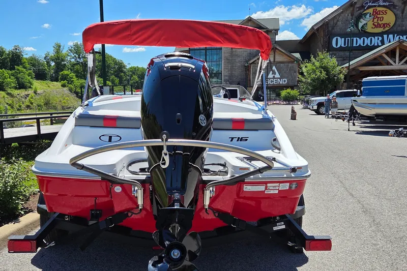 Slide: The Image of 2026 Tahoe T16 boat with red canopy parked outside Bass Pro Shops. - 2