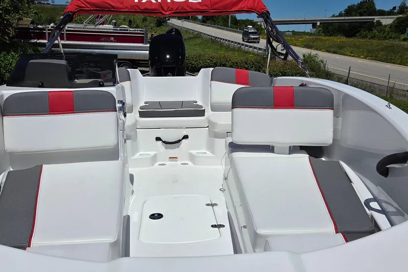 Slide: The Image of 2026 Tahoe T16 boat interior with white and red seating, parked near a highway. - 4