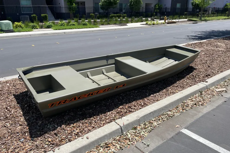 Slide: The Image of 2026 Tracker Grizzly 14 Jon boat parked on roadside, showcasing its sturdy design. - 3