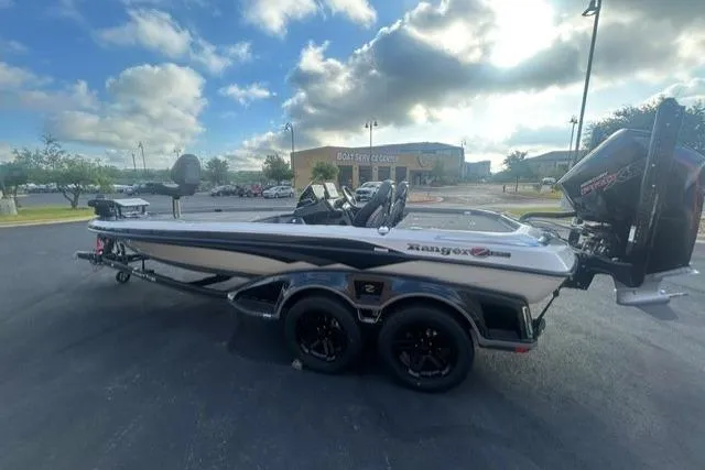 Slide: The Image of 2026 Ranger Z521R boat parked outdoors under a partly cloudy sky. - 3