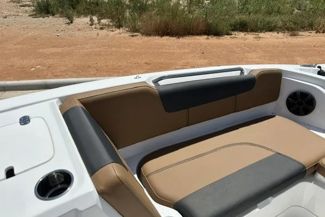 Slide: The Image of 2026 Tahoe 1950 boat interior with tan and black seating, cup holders, and speaker. - 17