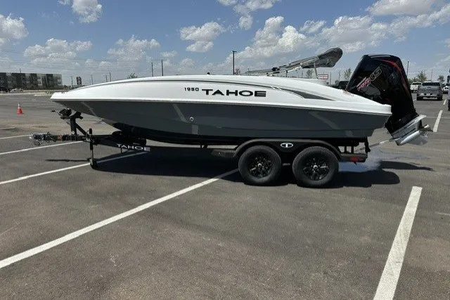 The Image of 2026 Tahoe 1950 boat on trailer in parking lot under blue sky. - 0