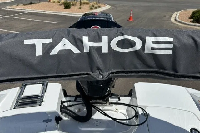 Slide: The Image of 2026 Tahoe 1950 boat with cover, parked in a lot. - 14
