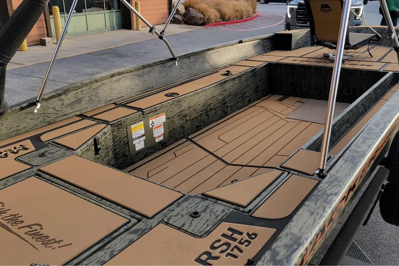 Slide: The Image of 2026 Tracker Grizzly 1756 T Marsh boat interior with camouflage design and seating arrangement. - 2