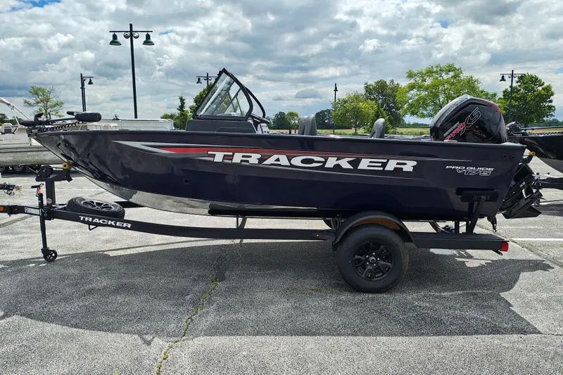 The Image of 2026 Tracker Pro Guide V-175 WT boat on trailer, parked outdoors under cloudy sky. - 0