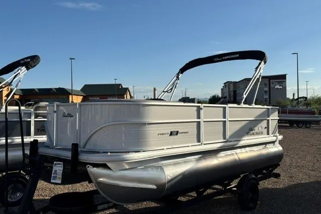 The Image of 2026 Sun Tracker Party Barge 18 DLX pontoon boat on trailer, parked outdoors. - 0