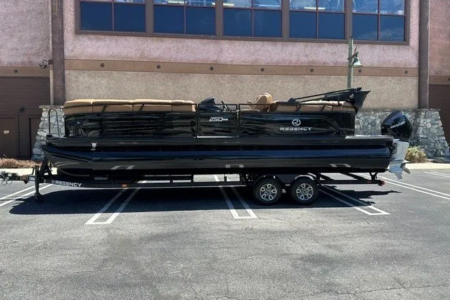 The Image of 2026 Regency 250 DL pontoon boat on trailer in parking lot. - 0