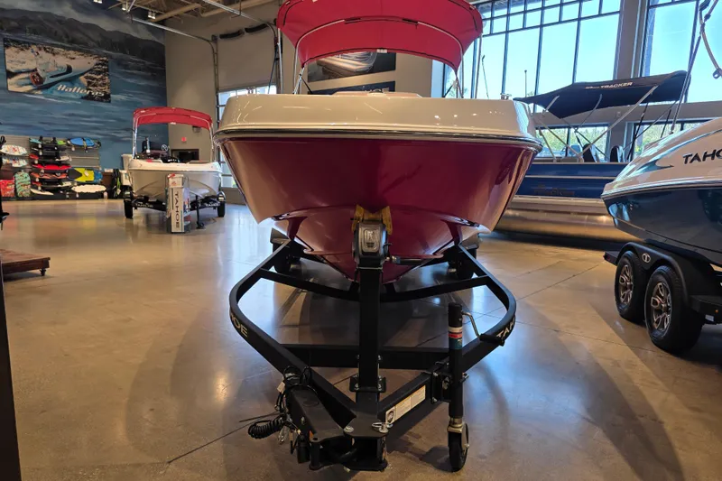 Slide: The Image of 2026 Tahoe T21 boat displayed in showroom, featuring sleek red and white design. - 2