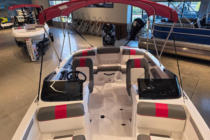 Slide: The Image of 2026 Tahoe T21 boat with red canopy and modern interior in showroom. - 3
