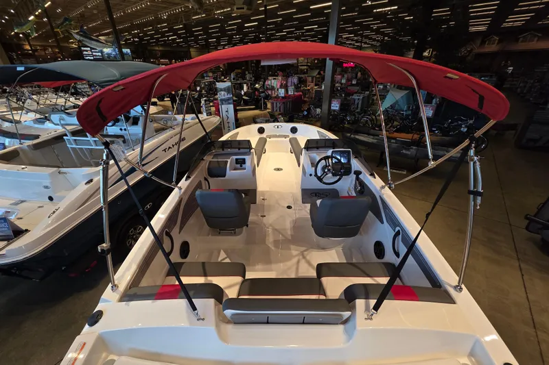 Slide: The Image of 2026 Tahoe T21 boat with red canopy displayed in a showroom. - 4