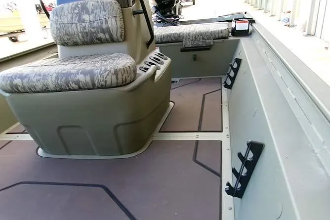 Slide: The Image of Interior of 2026 Tracker Grizzly 1860 CC boat with camo seating and rod holders. - 8