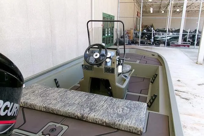 Slide: The Image of 2026 Tracker Grizzly 1860 CC boat interior with steering console and seating. - 3