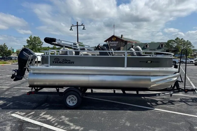 The Image of 2026 Sun Tracker Bass Buggy 18 DLX pontoon boat on trailer in parking lot. - 0