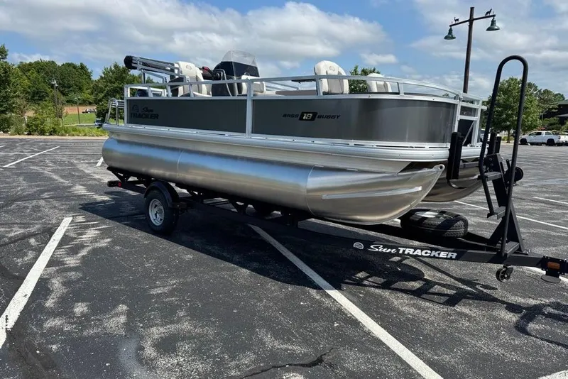 Slide: The Image of 2026 Sun Tracker Bass Buggy 18 DLX pontoon boat on trailer in parking lot. - 4