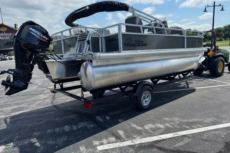 Slide: The Image of 2026 Sun Tracker Bass Buggy 18 DLX pontoon boat on trailer in parking lot. - 6
