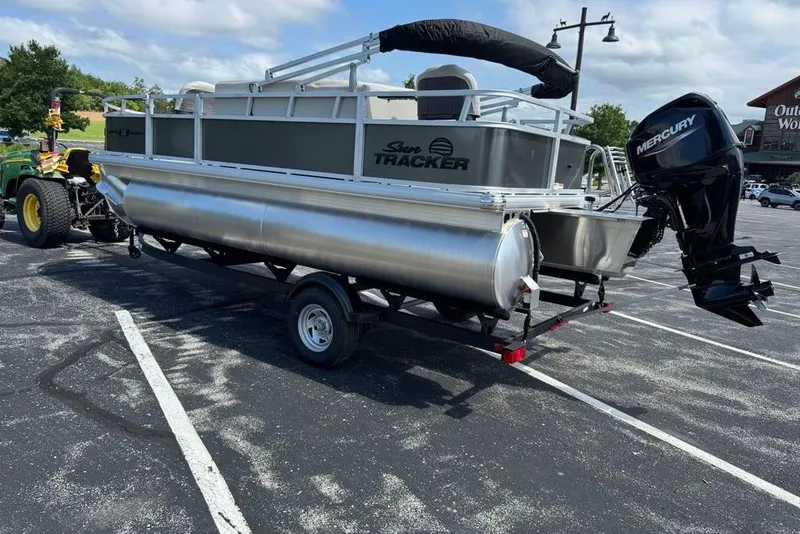 Slide: The Image of 2026 Sun Tracker Bass Buggy 18 DLX pontoon boat on trailer in parking lot. - 7