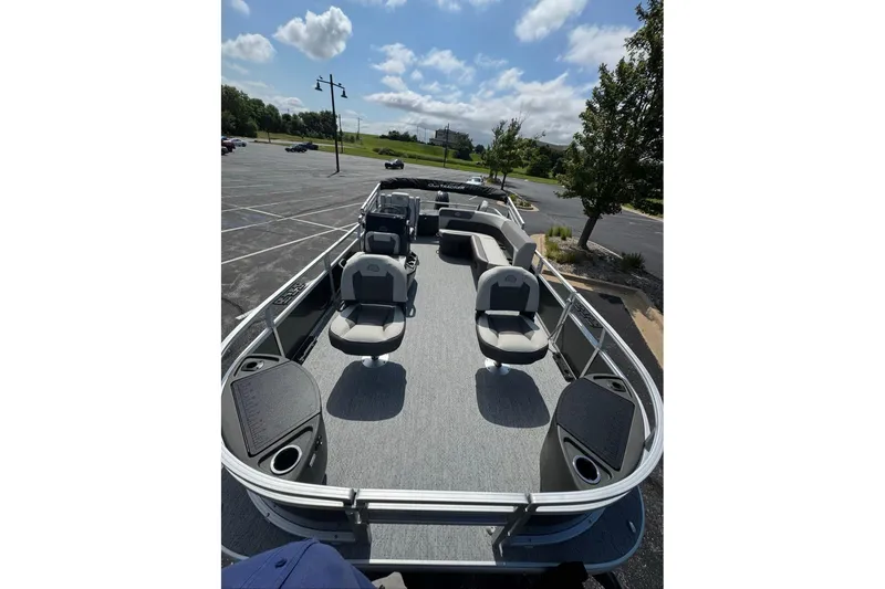 Slide: The Image of 2026 Sun Tracker Bass Buggy 18 DLX pontoon boat with spacious seating in a parking lot. - 87