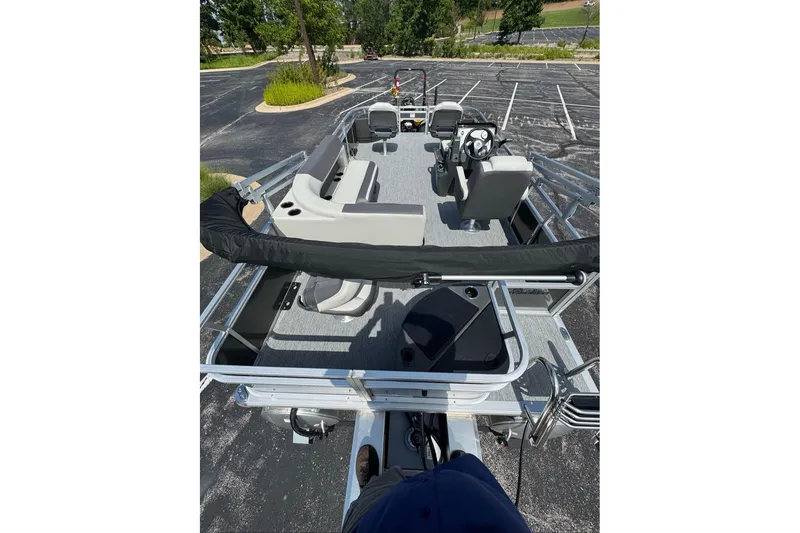 Slide: The Image of 2026 Sun Tracker Bass Buggy 18 DLX pontoon boat in a parking lot, top view. - 98