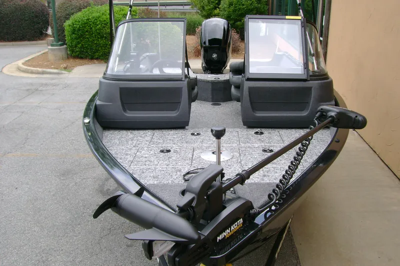 Slide: The Image of 2026 Tracker Pro Guide V-16 WT boat with Minn Kota trolling motor, parked outdoors. - 5