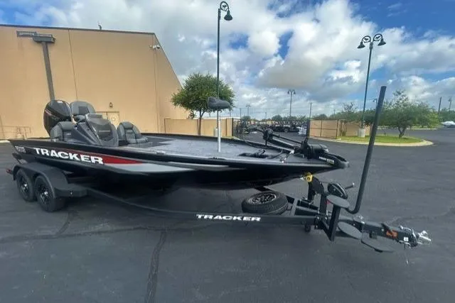 The Image of 2026 Tracker Savage 215 boat on trailer in parking lot, under cloudy sky. - 0