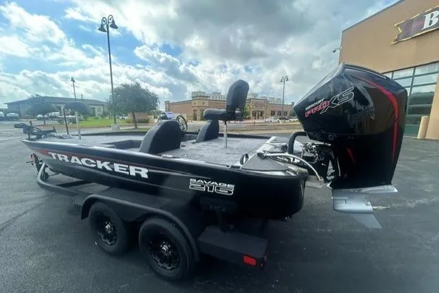 Slide: The Image of 2026 Tracker Savage 215 boat with powerful outboard motor, parked outdoors. - 2