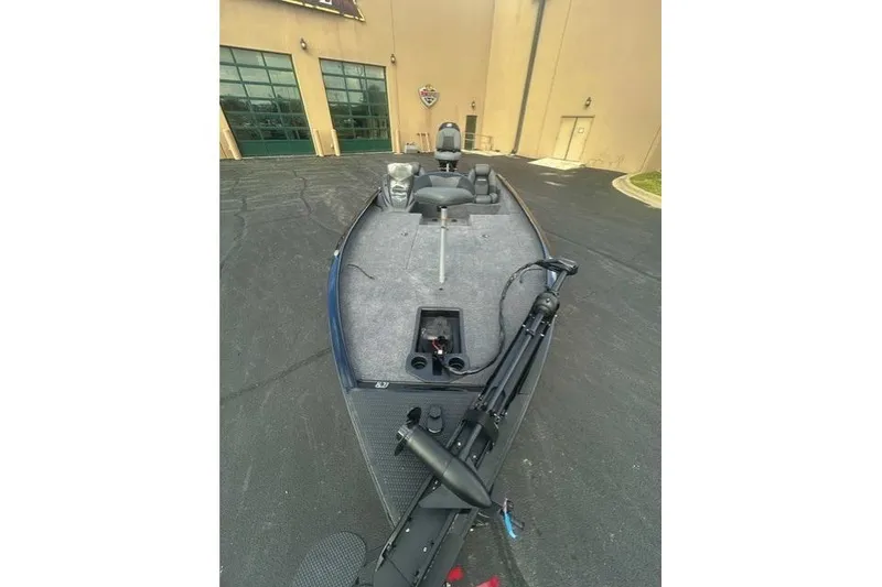 Slide: The Image of 2026 Tracker Savage 215 boat parked outside a building, showcasing its deck and seating. - 4